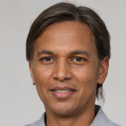 Joyful latino adult male with short  brown hair and brown eyes
