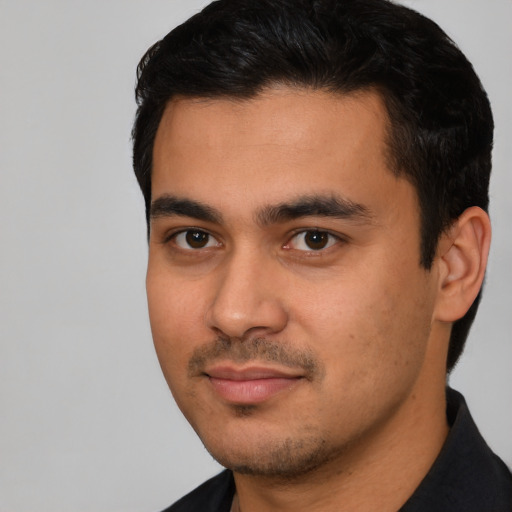 Joyful latino young-adult male with short  black hair and brown eyes