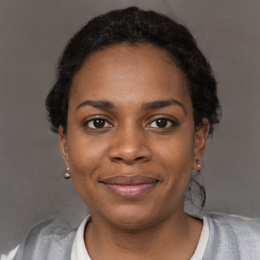 Joyful black young-adult female with short  black hair and brown eyes