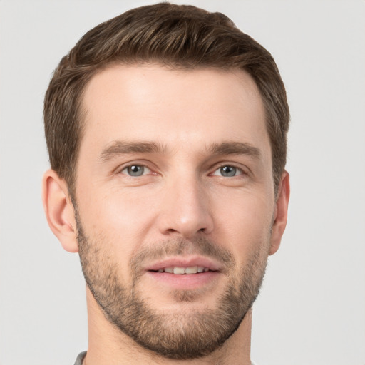 Joyful white young-adult male with short  brown hair and grey eyes