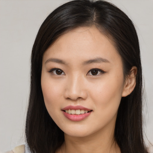 Joyful asian young-adult female with long  brown hair and brown eyes
