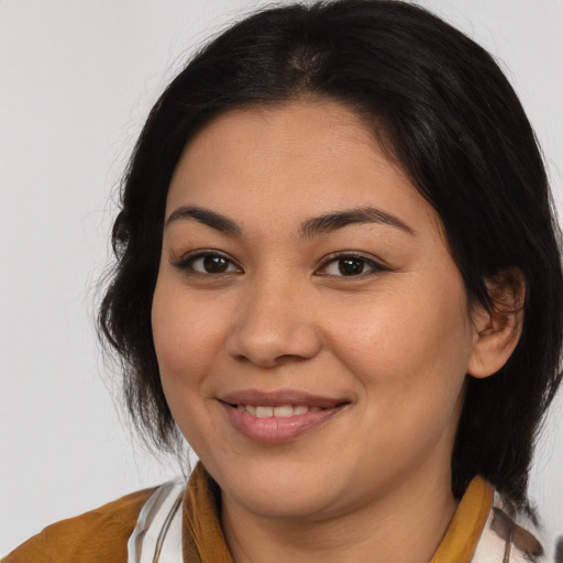 Joyful latino young-adult female with medium  brown hair and brown eyes