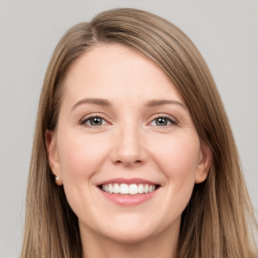 Joyful white young-adult female with long  brown hair and grey eyes