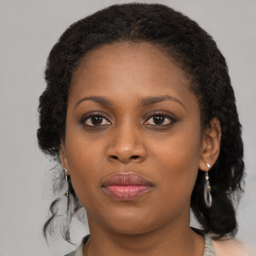 Joyful black young-adult female with medium  brown hair and brown eyes