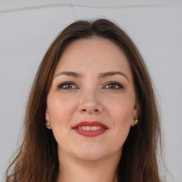 Joyful white adult female with long  brown hair and grey eyes