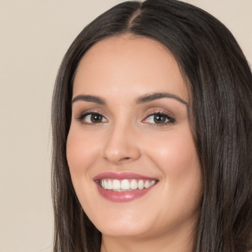 Joyful white young-adult female with long  black hair and brown eyes