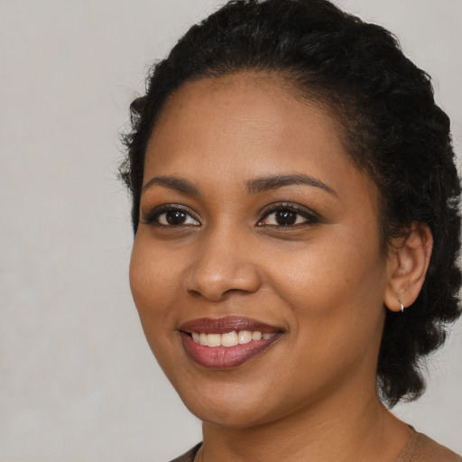 Joyful black young-adult female with medium  black hair and brown eyes