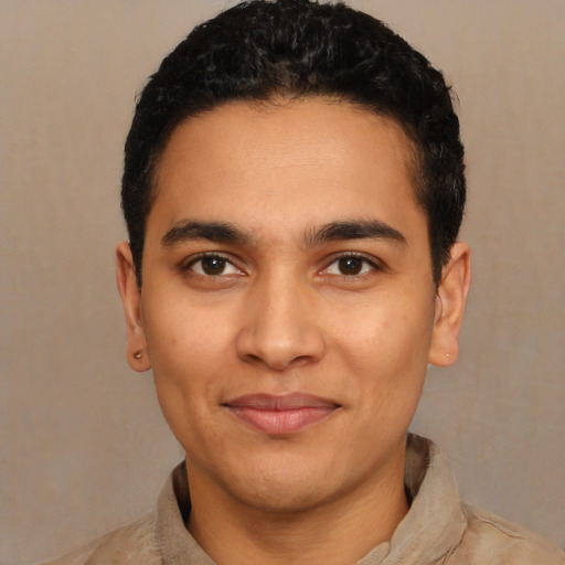 Joyful latino young-adult male with short  black hair and brown eyes