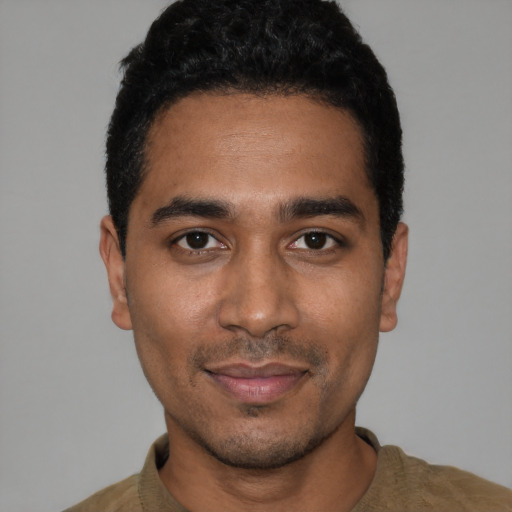 Joyful latino young-adult male with short  black hair and brown eyes