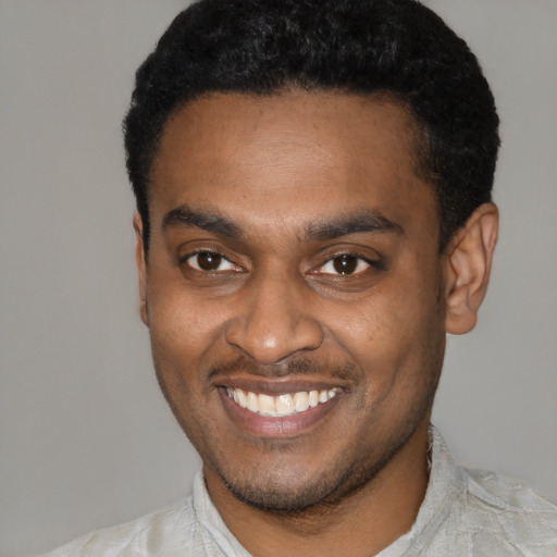 Joyful latino young-adult male with short  black hair and brown eyes