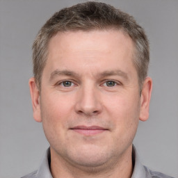 Joyful white adult male with short  brown hair and grey eyes