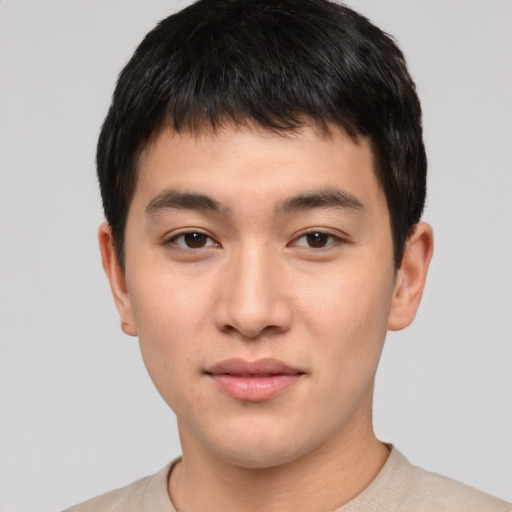 Joyful asian young-adult male with short  brown hair and brown eyes