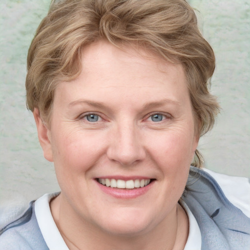 Joyful white adult female with short  brown hair and blue eyes