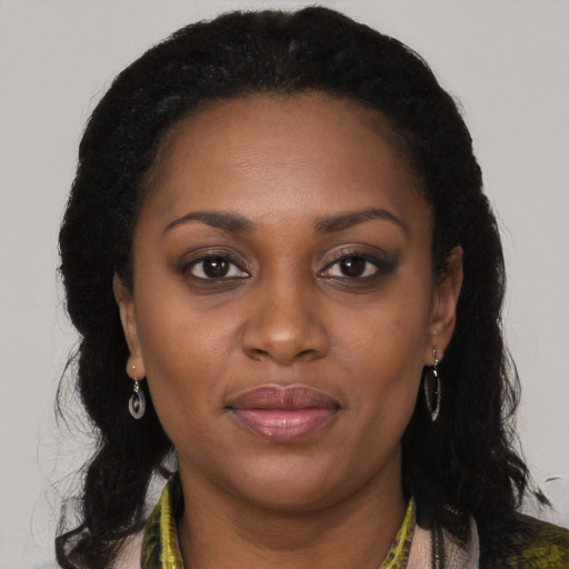 Joyful black young-adult female with long  brown hair and brown eyes
