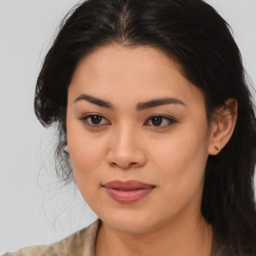 Joyful latino young-adult female with long  brown hair and brown eyes