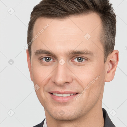 Joyful white young-adult male with short  brown hair and brown eyes