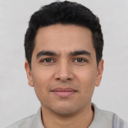 Joyful latino young-adult male with short  black hair and brown eyes