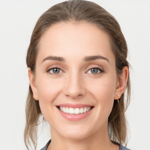 Joyful white young-adult female with medium  brown hair and grey eyes