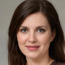 Joyful white young-adult female with long  brown hair and green eyes