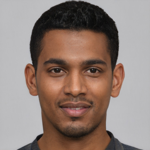 Joyful black young-adult male with short  black hair and brown eyes