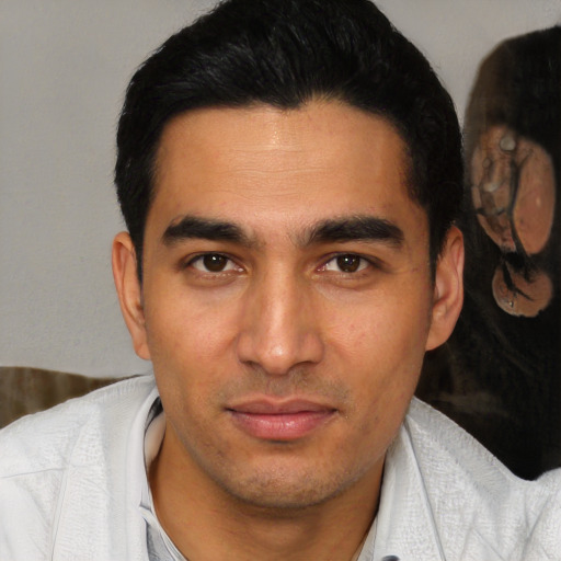 Joyful latino young-adult male with short  brown hair and brown eyes