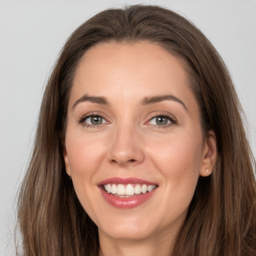 Joyful white young-adult female with long  brown hair and grey eyes