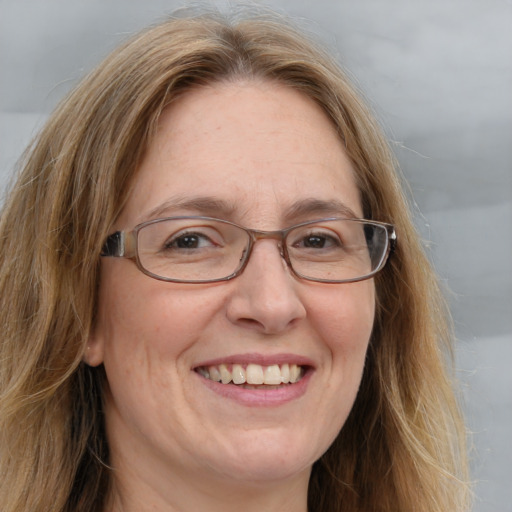 Joyful white adult female with long  brown hair and blue eyes