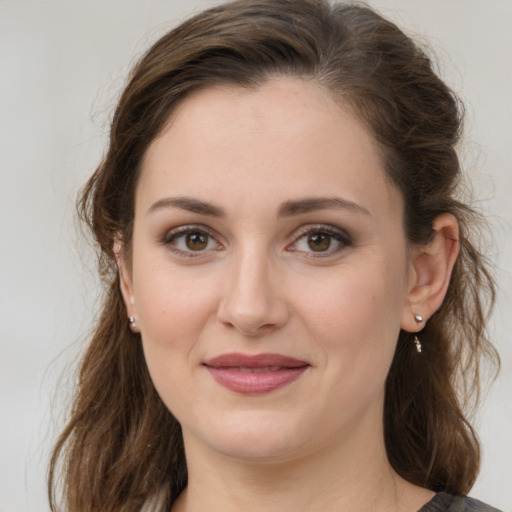 Joyful white young-adult female with medium  brown hair and green eyes