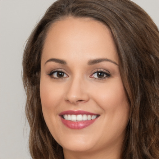 Joyful white young-adult female with long  brown hair and brown eyes