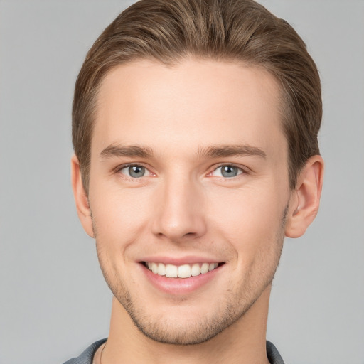 Joyful white young-adult male with short  brown hair and grey eyes