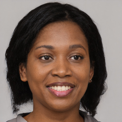 Joyful black young-adult female with medium  black hair and brown eyes
