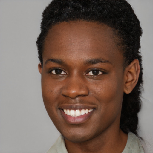 Joyful black young-adult male with short  brown hair and brown eyes