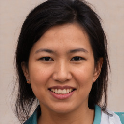 Joyful asian young-adult female with medium  brown hair and brown eyes