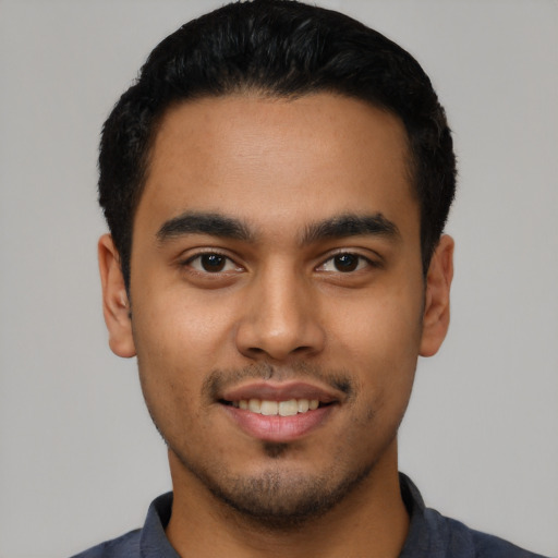 Joyful latino young-adult male with short  black hair and brown eyes