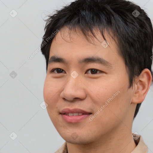 Joyful asian young-adult male with short  brown hair and brown eyes