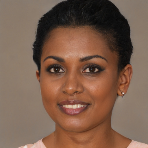 Joyful black young-adult female with short  black hair and brown eyes