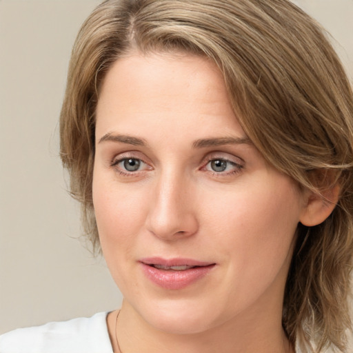 Joyful white young-adult female with medium  brown hair and green eyes