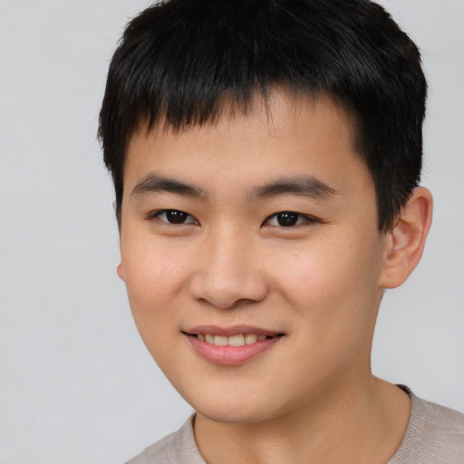 Joyful asian young-adult male with short  brown hair and brown eyes