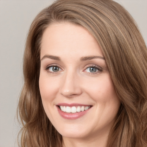 Joyful white young-adult female with long  brown hair and green eyes