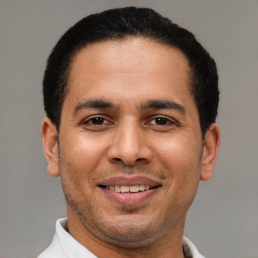 Joyful latino adult male with short  brown hair and brown eyes