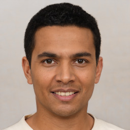 Joyful latino young-adult male with short  black hair and brown eyes