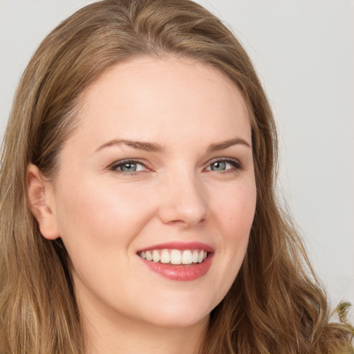 Joyful white young-adult female with long  brown hair and green eyes