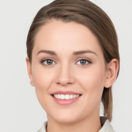 Joyful white young-adult female with medium  brown hair and grey eyes