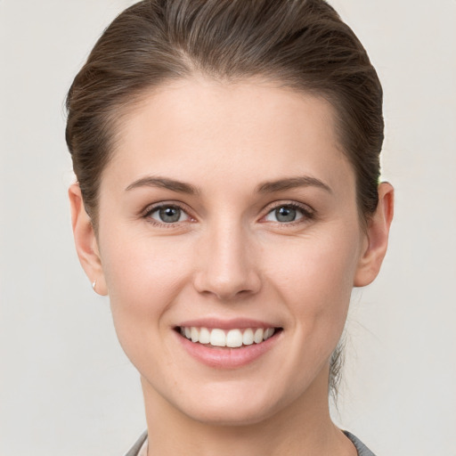 Joyful white young-adult female with short  brown hair and grey eyes