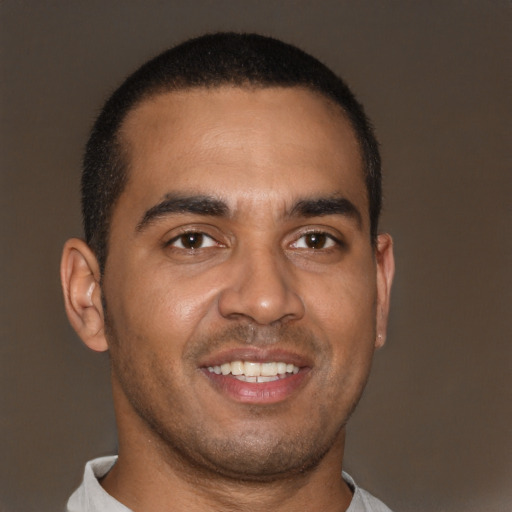 Joyful latino young-adult male with short  brown hair and brown eyes