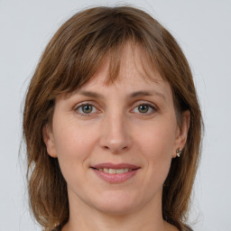 Joyful white young-adult female with long  brown hair and grey eyes