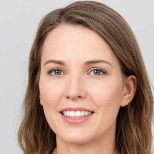 Joyful white young-adult female with long  brown hair and grey eyes