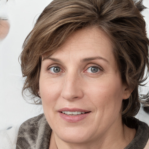 Joyful white adult female with medium  brown hair and blue eyes