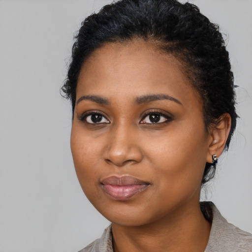 Joyful black young-adult female with medium  black hair and brown eyes
