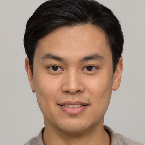 Joyful white young-adult male with short  black hair and brown eyes